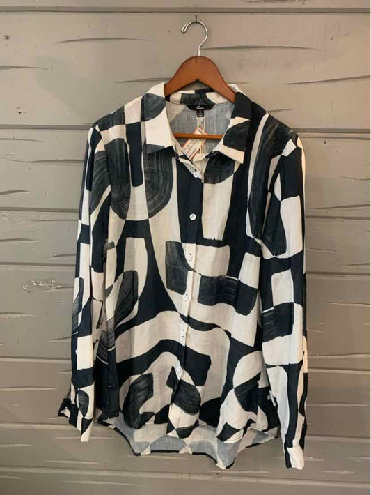 Long-sleeve black and white abstract patterned button-up shirt in XL hanging on wooden hanger.