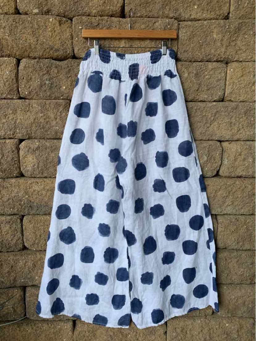White wide-leg pants with large irregular navy blue polka dots and an elastic waistband.