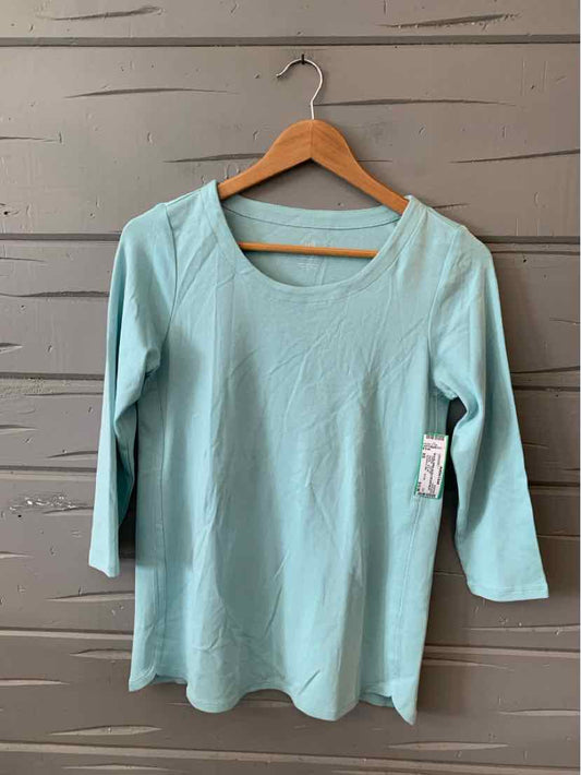 Light blue women's long-sleeve scoop neck top in size XS hanging on wooden hanger against gray wooden wall.