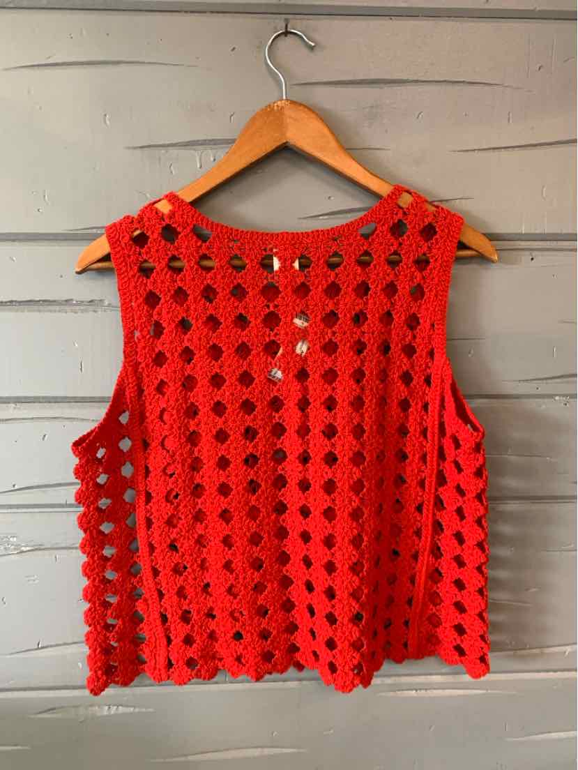 Bright pink crochet sleeveless top with scalloped edges and round neckline.