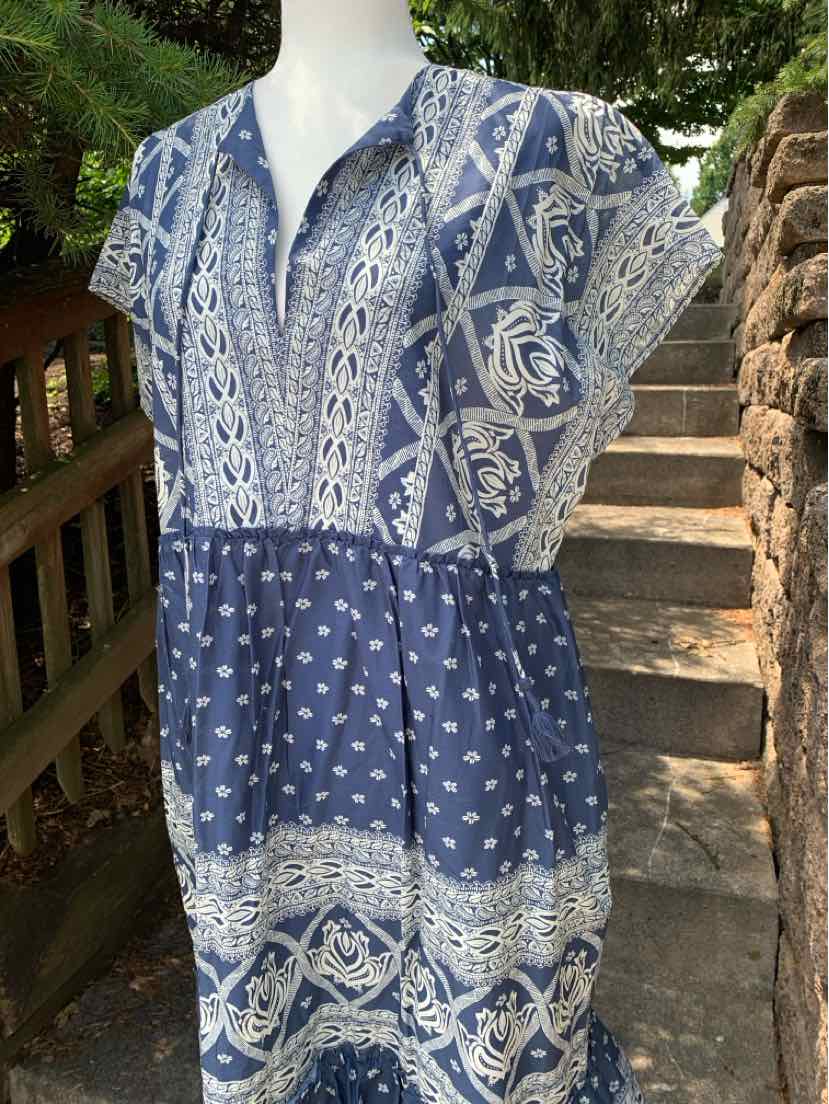 Blue boho-style dress with white floral and geometric patterns, short sleeves, and V-neckline.