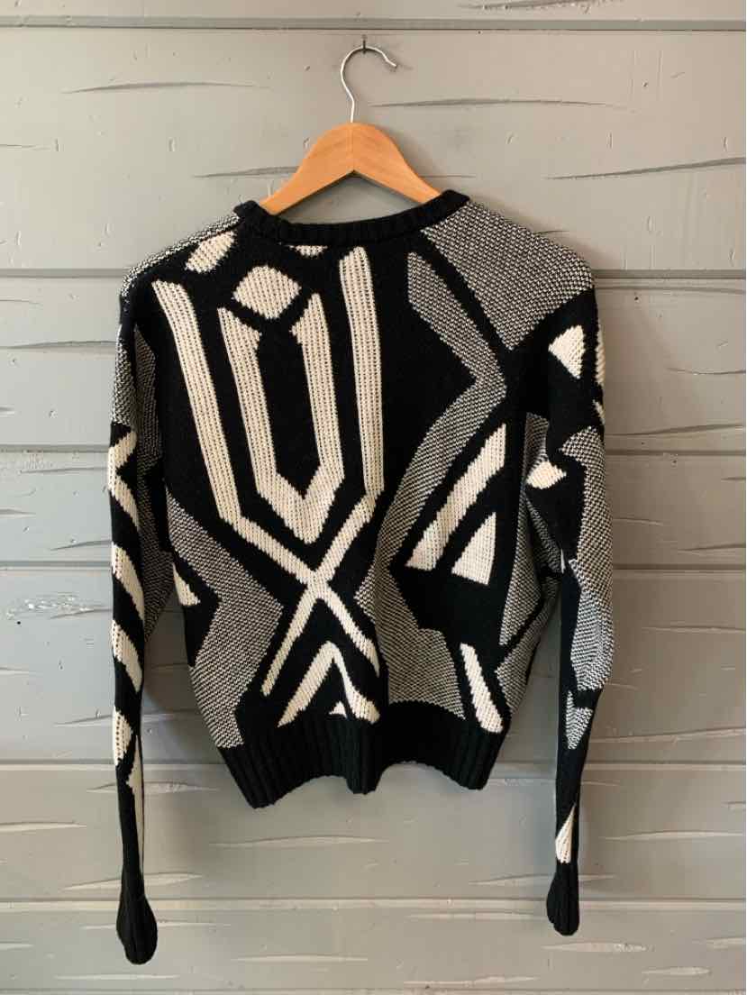 Black and gray geometric patterned knit sweater with long sleeves and ribbed cuffs and hem.