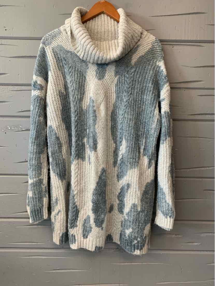 Oversized knit sweater with blue and cream abstract pattern, chunky turtleneck collar.