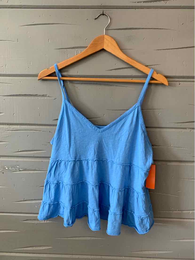 Light blue tiered camisole with thin adjustable straps and flowy fabric on wooden hanger.