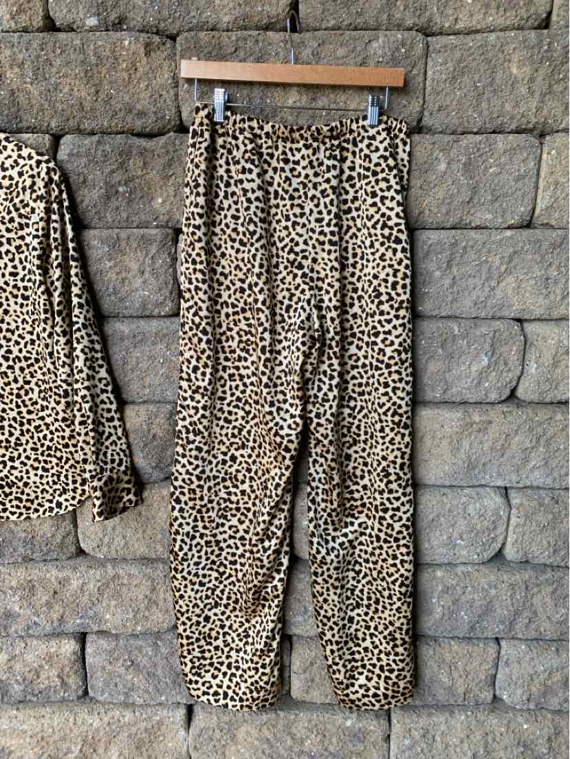 High-waisted cheetah print pants with elastic waistband and tapered legs in light brown and black tones.