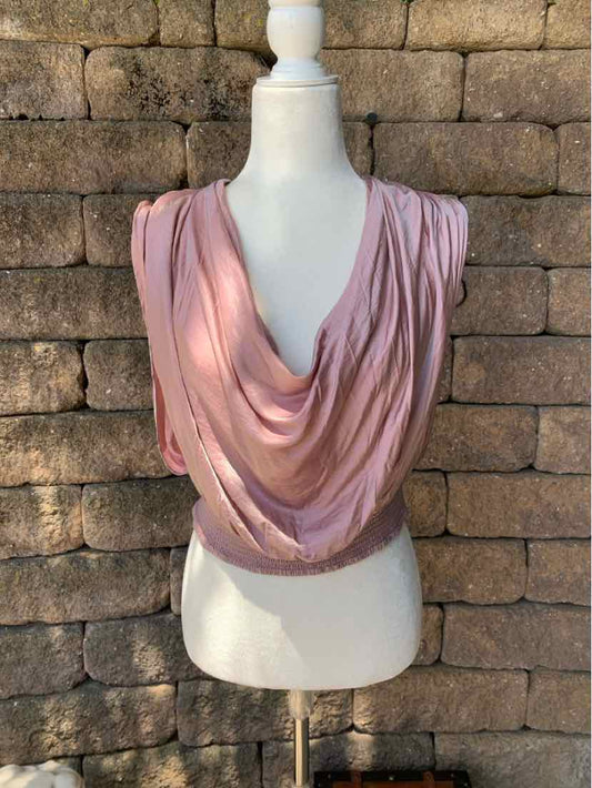 Soft pink draped sleeveless top with cowl neckline and fitted waist on mannequin.