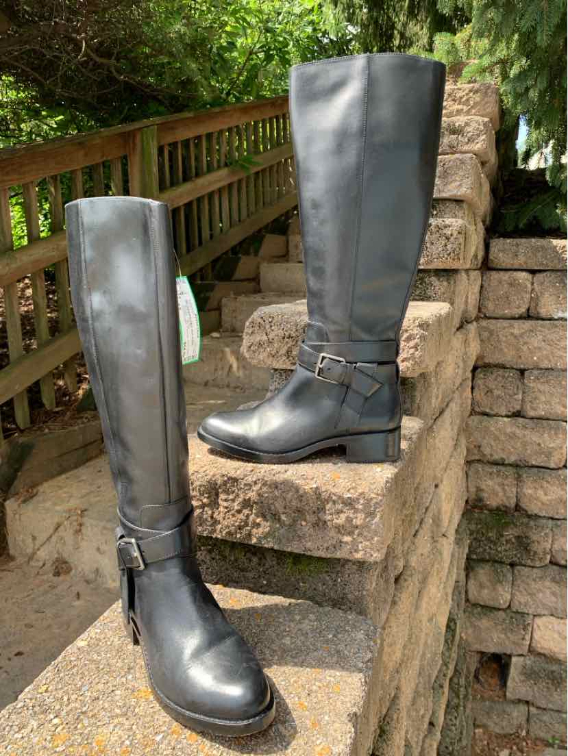 Black leather knee-high boots with low heel and ankle strap buckle detail.