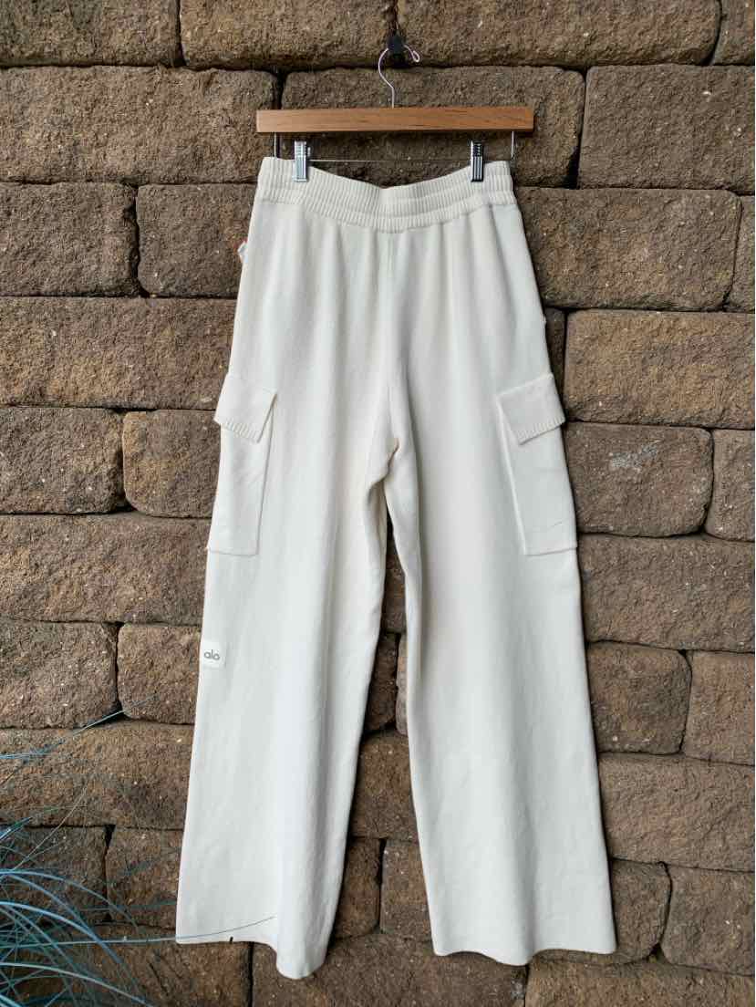 White wide-leg knit pants with elastic waistband and side cargo pockets.