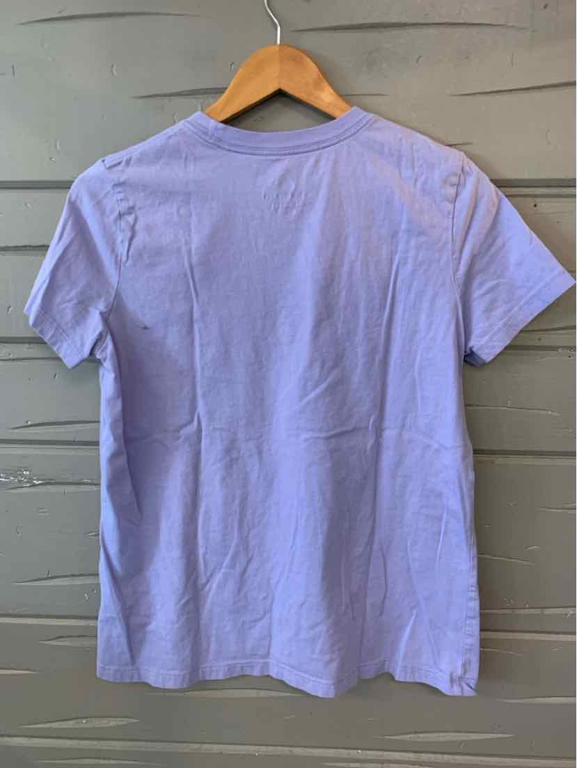 Lavender short-sleeve cotton T-shirt with crew neck and relaxed fit hanging on wooden hanger.