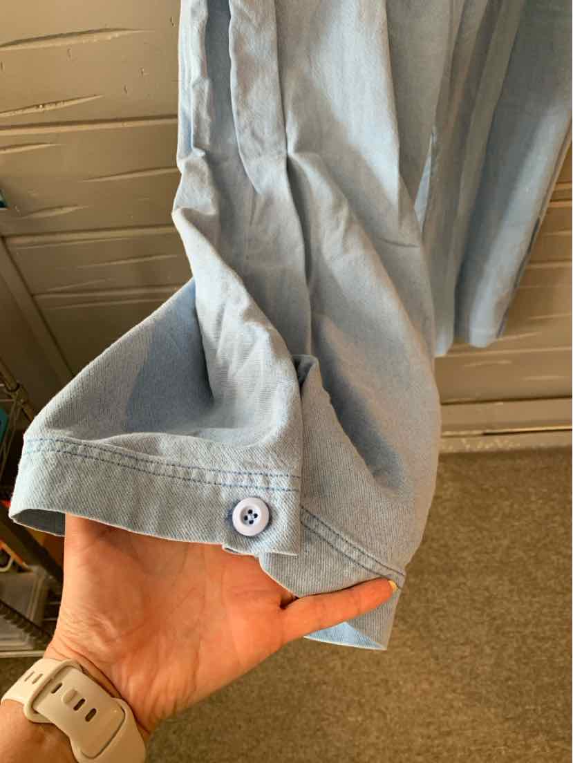 Light blue casual pants cuffed at the hem with a small white button detail.