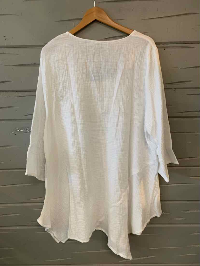 White oversized blouse with three-quarter bell sleeves and rounded hem on wooden hanger.