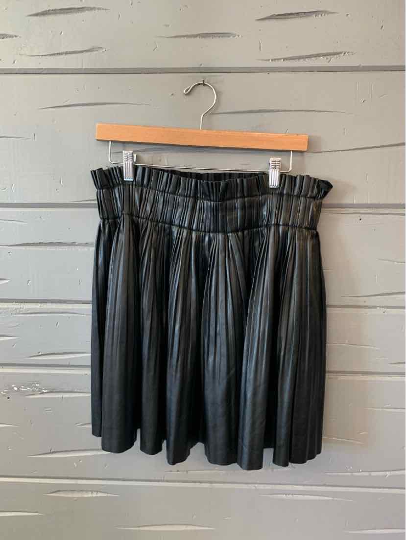 Black faux leather pleated mini skirt with waistband, size XL on wooden hanger.