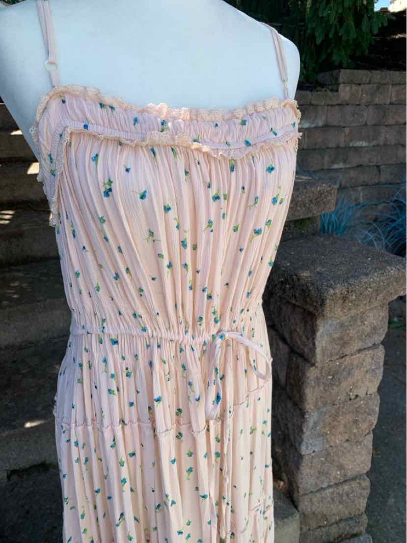 Light pink floral sundress with thin straps, smocked bodice, and adjustable waist tie.