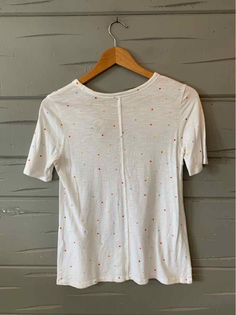 White short-sleeve top with small multicolored polka dots and a center back seam.
