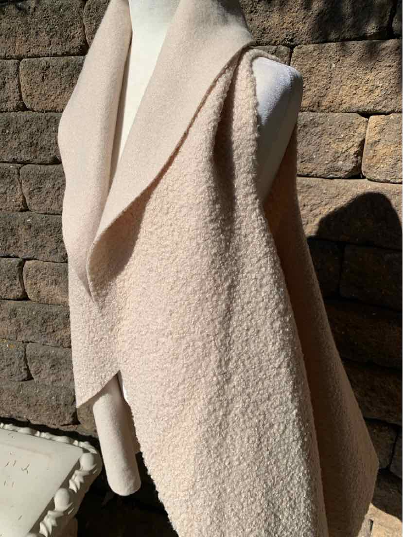 Beige boucle wool coat with a soft, textured finish and relaxed draped shape.