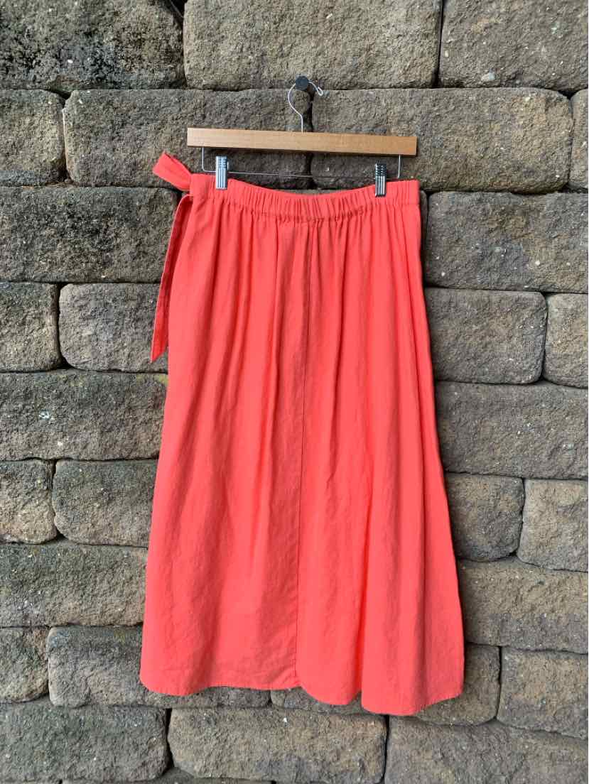 Coral pink midi skirt with side tie belt, gathered waist, and lightweight flowy fabric.