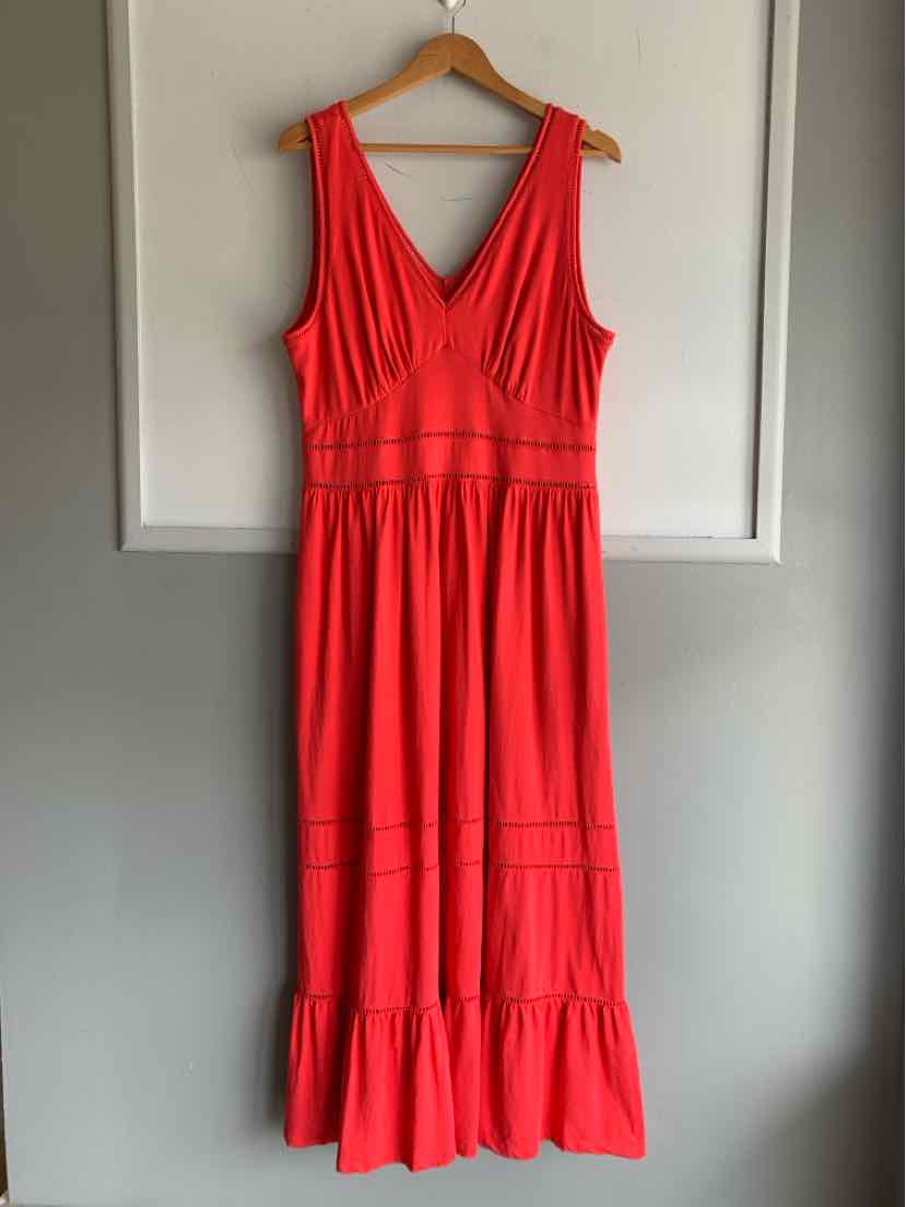 Sleeveless coral midi dress with V-neck, gathered waist, and ruffled hem on wooden hanger.