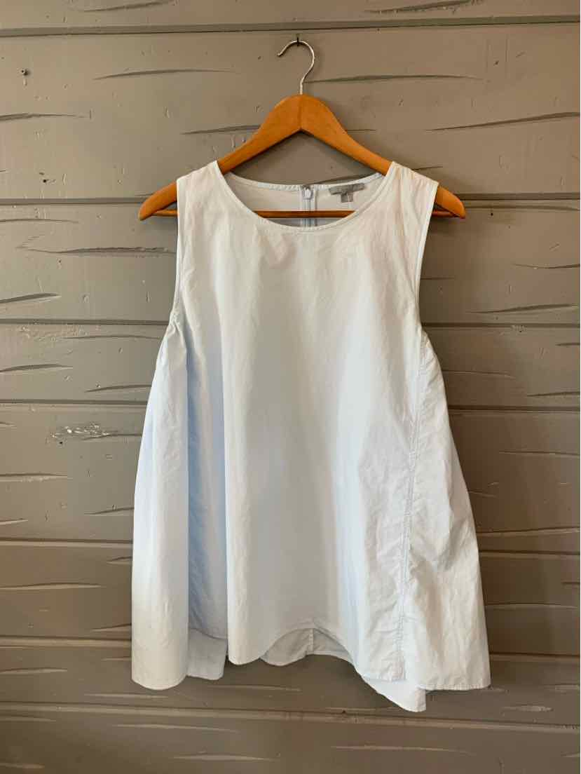 White sleeveless blouse with wide armholes and flared silhouette on wooden hanger.