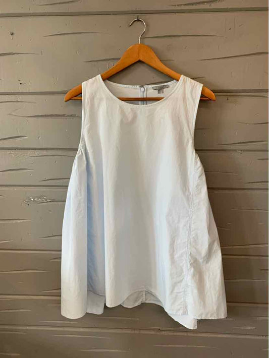 White sleeveless blouse with wide armholes and flared silhouette on wooden hanger.