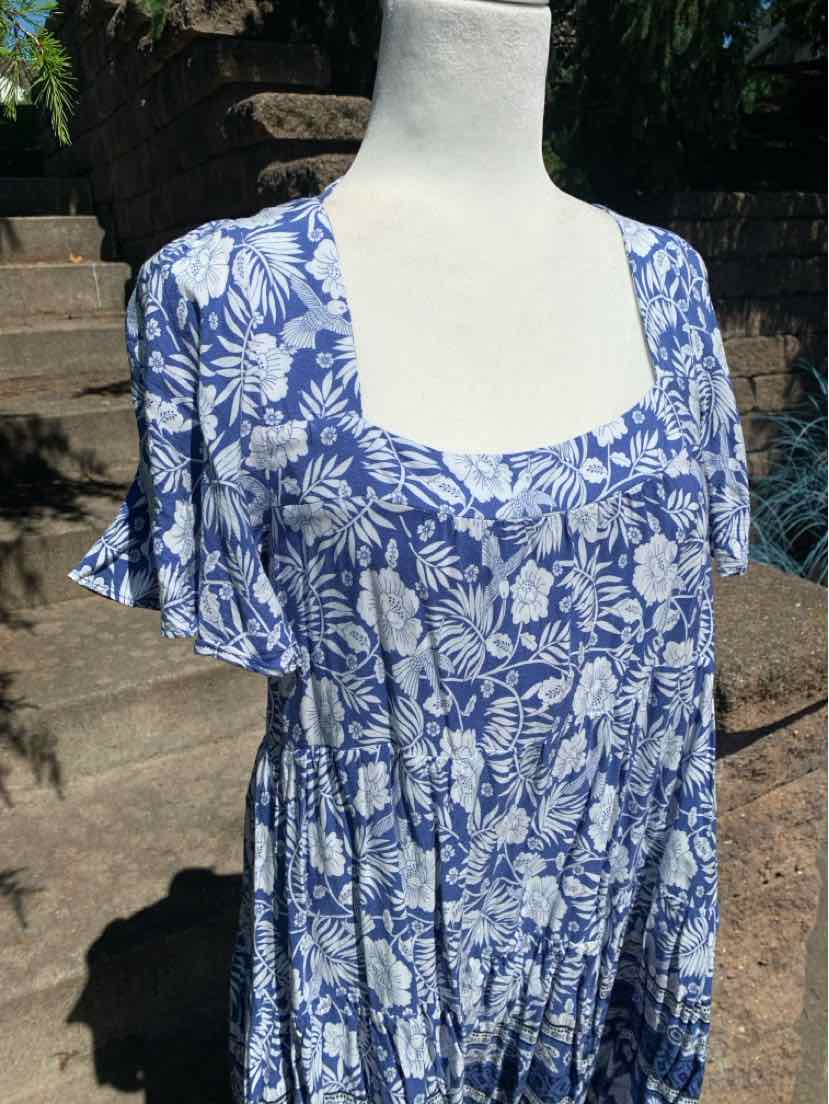 Blue and white floral print dress with square neckline and flutter sleeves on mannequin outdoors.