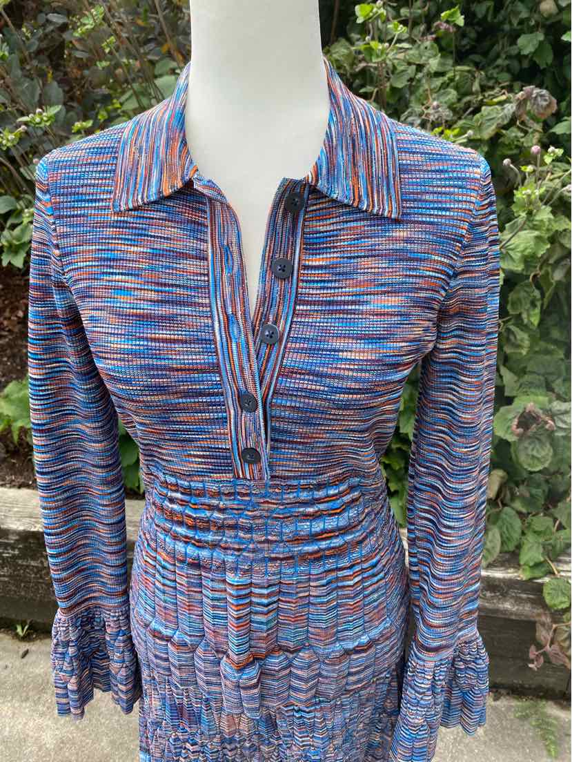 Long-sleeve ribbed knit top with blue, pink, and orange space-dyed pattern, button-up collar, and fitted waist.