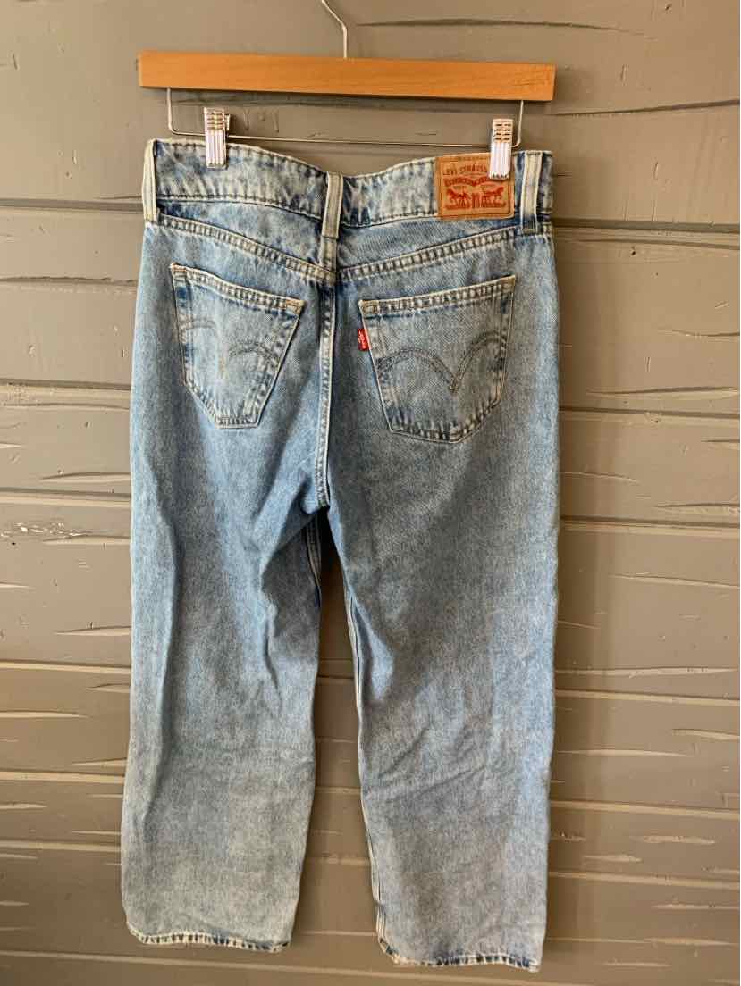 Light blue denim Levi’s jeans with straight leg cut, classic five-pocket design, and leather brand patch on waistband.
