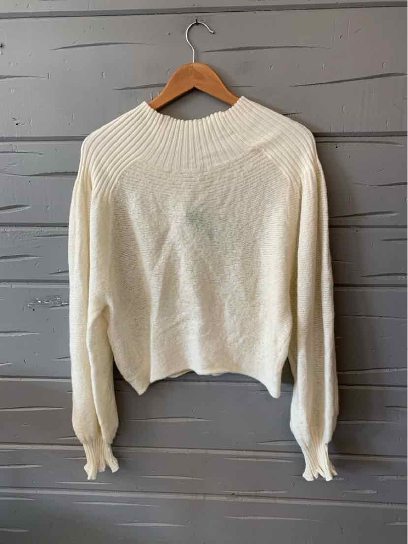 Ivory knit sweater with ribbed crew neckline and long puffed sleeves.