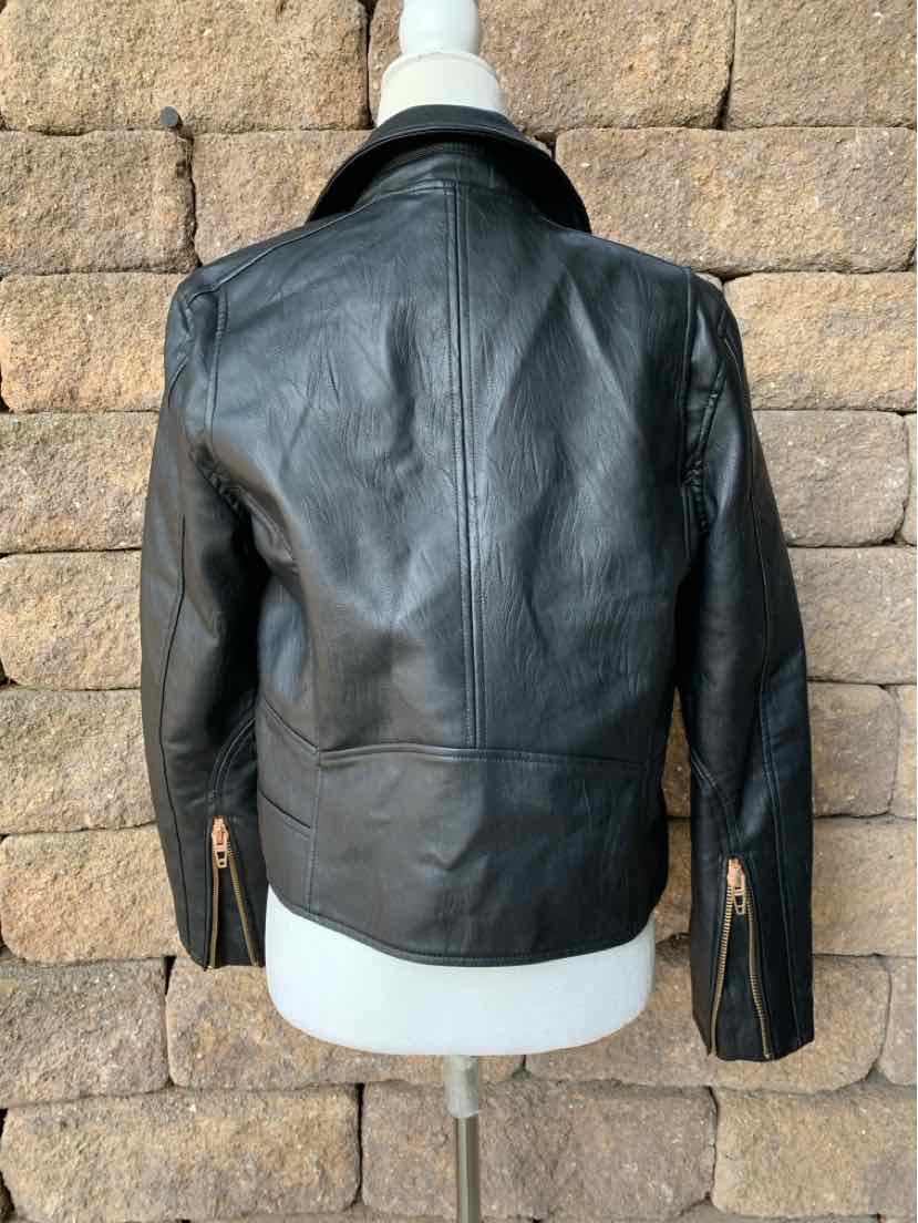 Black leather jacket with zipper cuffs and a fitted waist shown from the back on a mannequin.