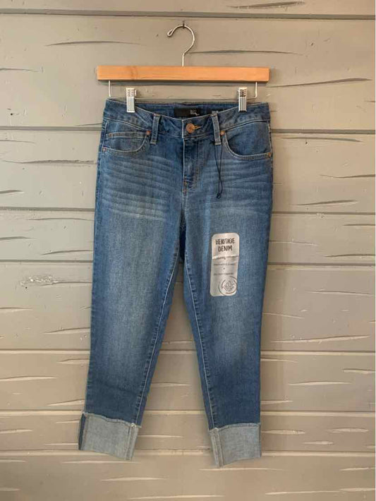 Blue cuffed denim jeans with faded details and a front patch label, size 4.