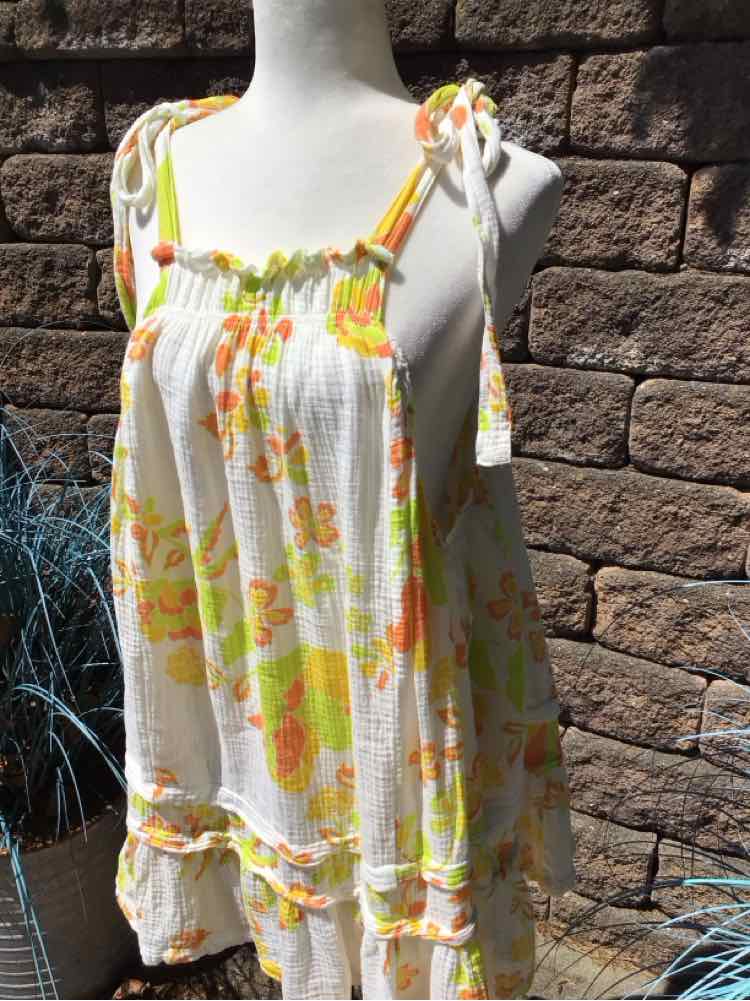 White sleeveless dress with yellow and orange floral print and tie straps.