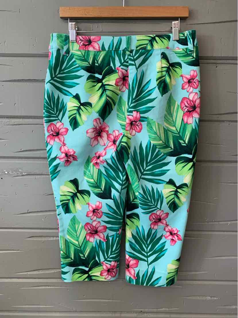 High-waisted tropical print skirt with green palm leaves and pink flowers on light blue background.