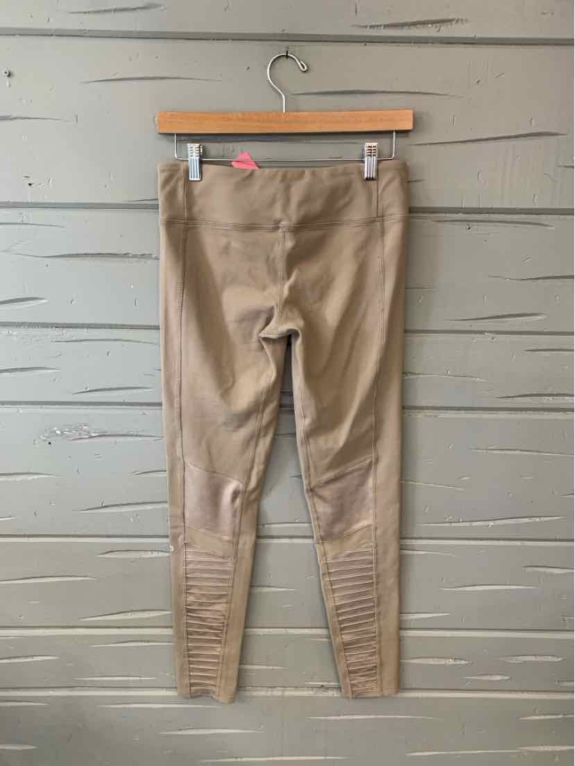 Beige high-waist leggings with ribbed detailing on lower legs hanging on wooden hanger.