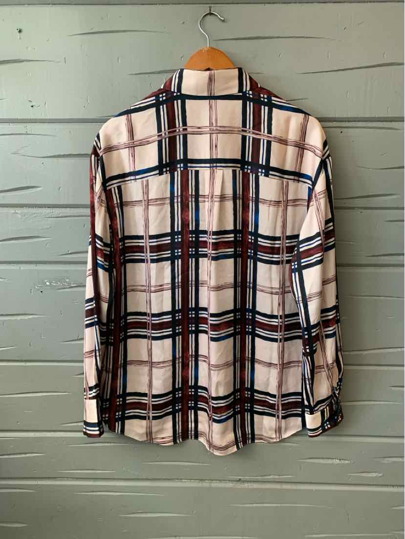 Long-sleeve plaid shirt in cream with navy and red lines hanging on wooden hanger.