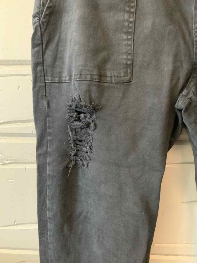 Gray pants with large rectangular patch pocket and distressed detail above knee.