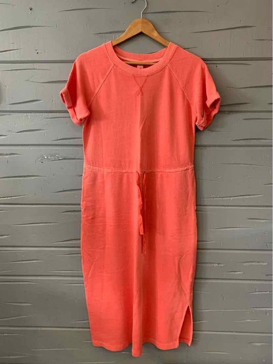 Coral short-sleeve midi dress with round neckline and waist tie belt on wooden hanger.