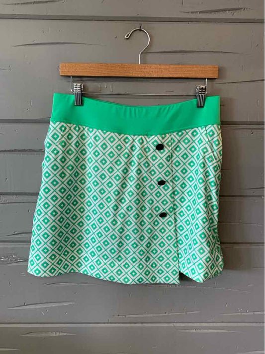 Green and white geometric patterned mini skirt with solid green waistband and front button detail.
