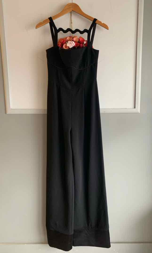 Black wide-leg jumpsuit with floral embroidery on square neckline and thin straps.