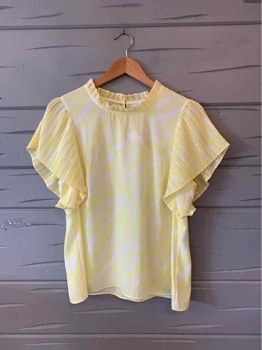 Light yellow floral blouse with ruffled short sleeves and round neckline.