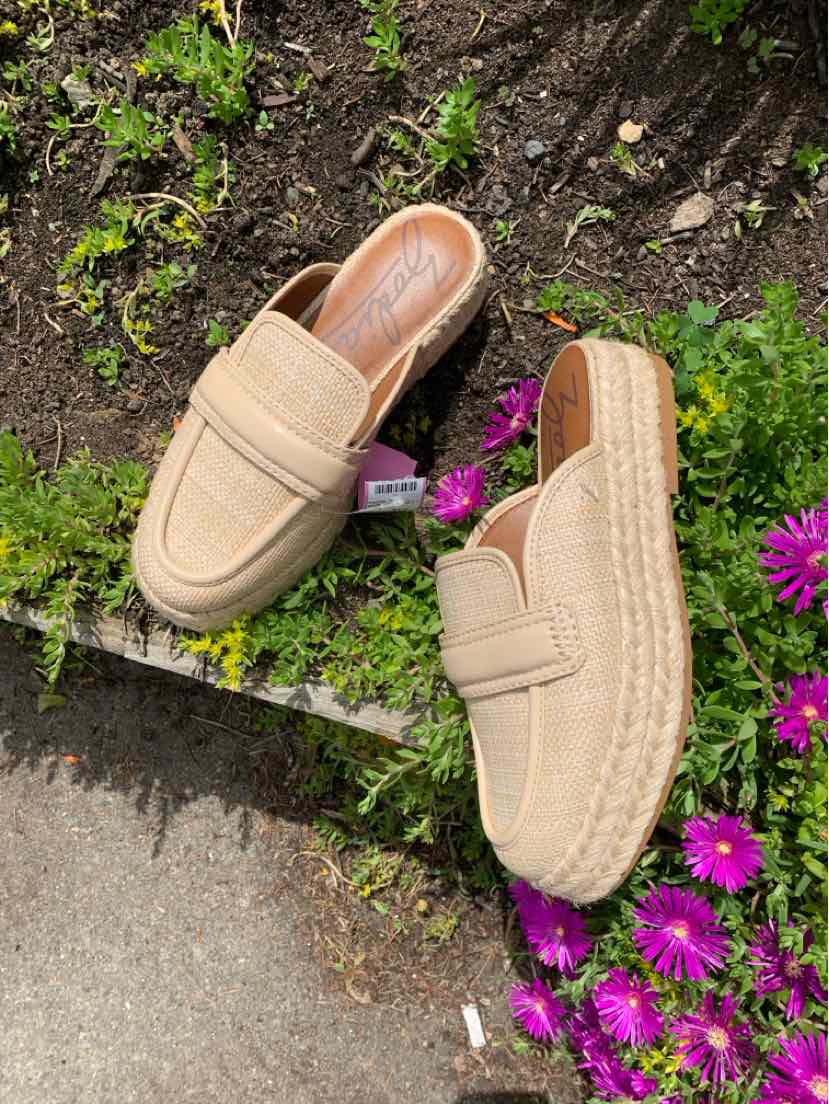 Tan slip-on espadrille shoe with woven jute platform sole and stitched leather upper.