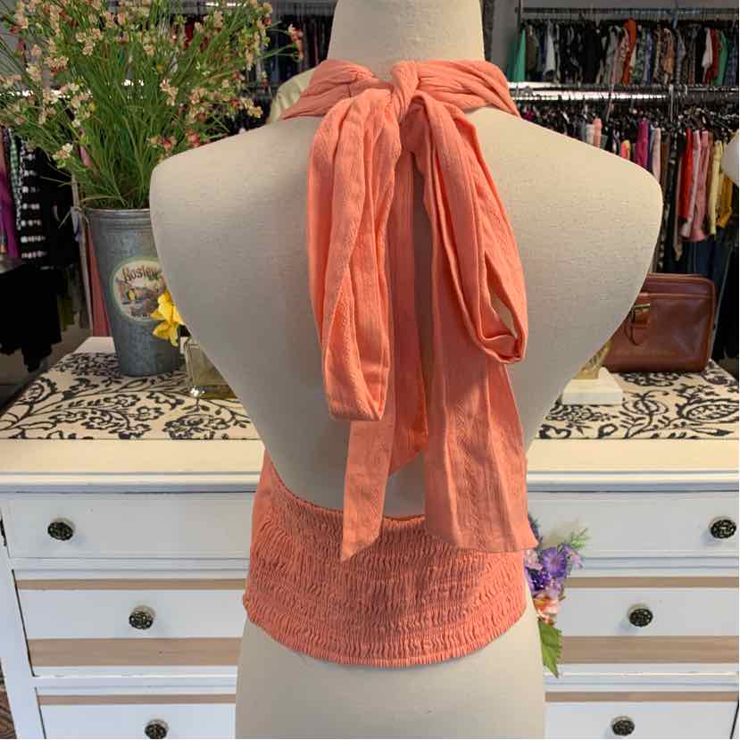 Coral orange sleeveless halter top with tie closure and smocked back detail.