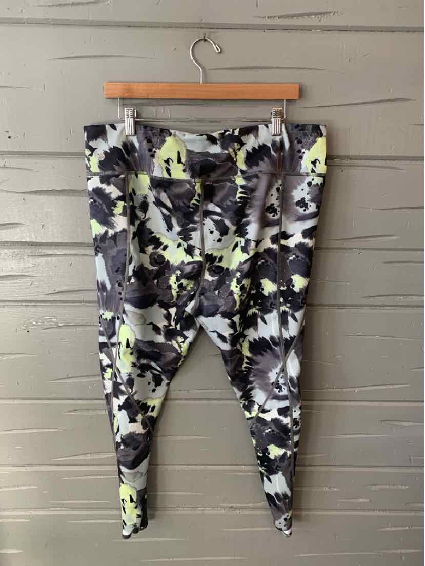 Multi-color abstract print leggings with tapered ankles, size 2X, hanging on wooden hanger.