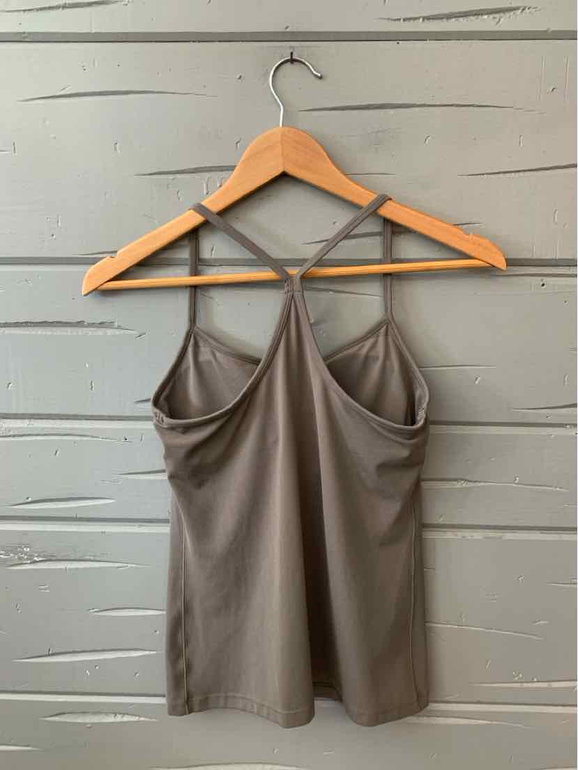 Taupe sleeveless camisole with thin straps and a relaxed fit, hanging on wooden hanger.