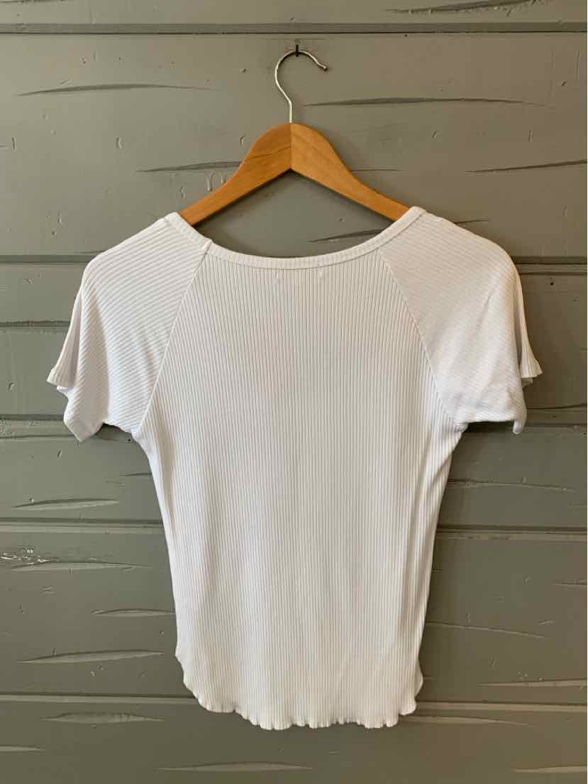 White short-sleeve ribbed knit top with scalloped edges on sleeves and hem, hanging on wooden hanger.