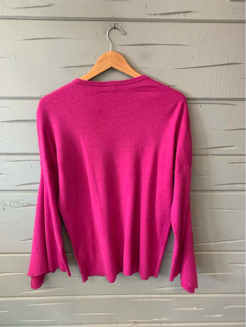 Fuchsia long-sleeve knit sweater with scalloped hem and relaxed fit on wooden hanger.