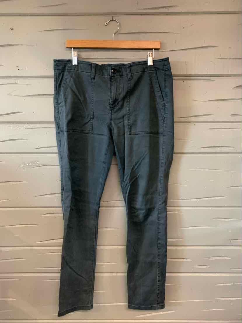 Gray slim-fit pants with front pockets and belt loops hanging on wooden hanger.