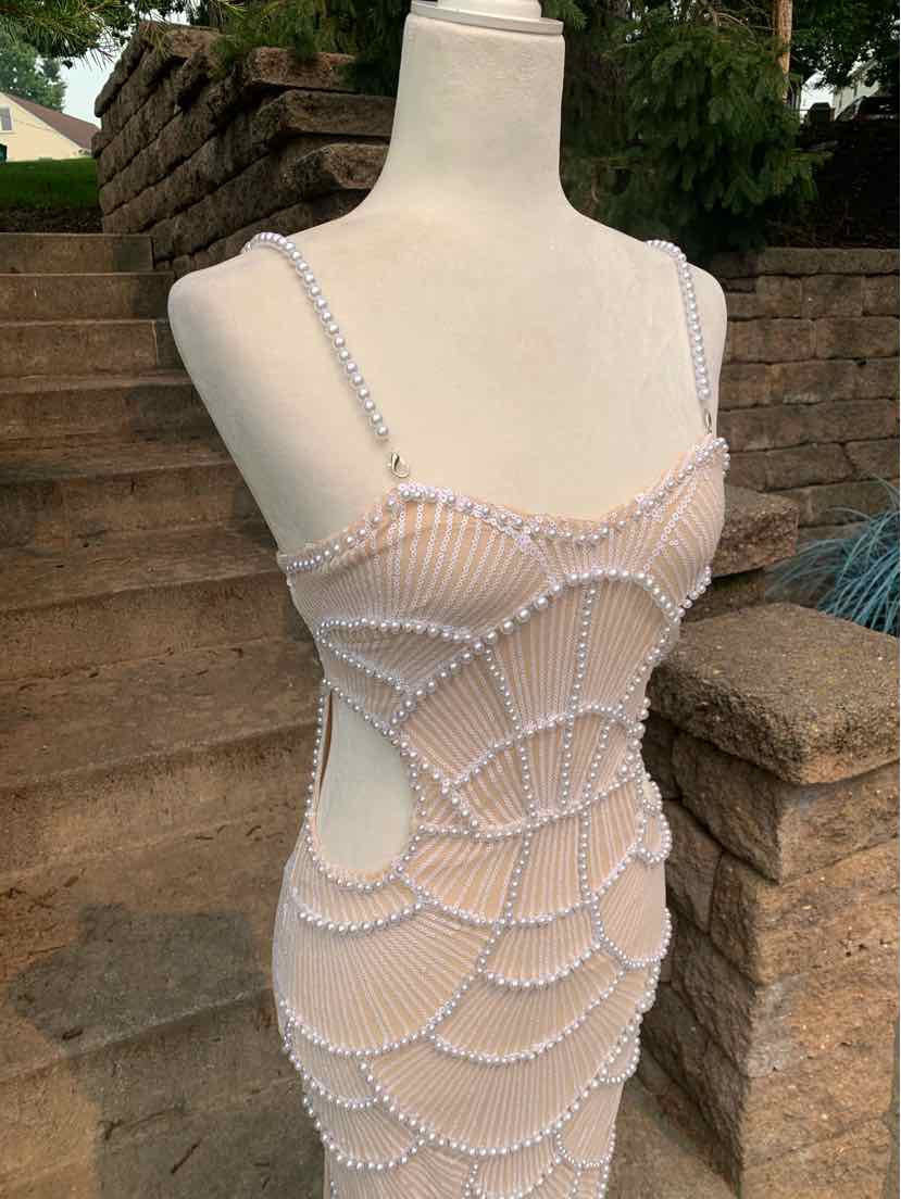 Tan sleeveless dress with intricate white beaded web-like pattern, fitted silhouette, and thin straps.