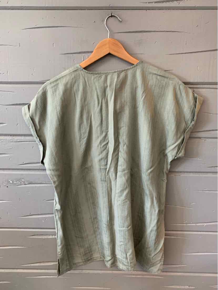 Light green short-sleeve blouse with loose fit and subtle cuffed sleeves on wooden hanger.