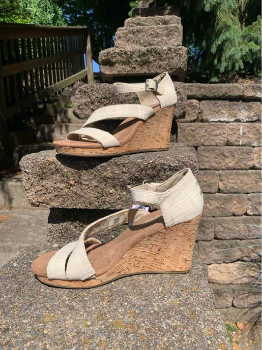 Beige canvas wedge sandals with ankle strap and cork platform sole, size 7.