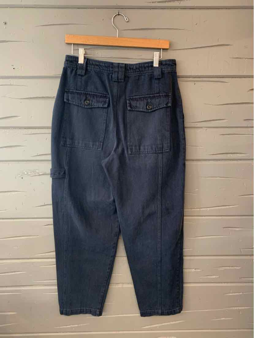 High-waist dark navy pants with back flap pockets and straight tapered legs hanging on wood hanger.
