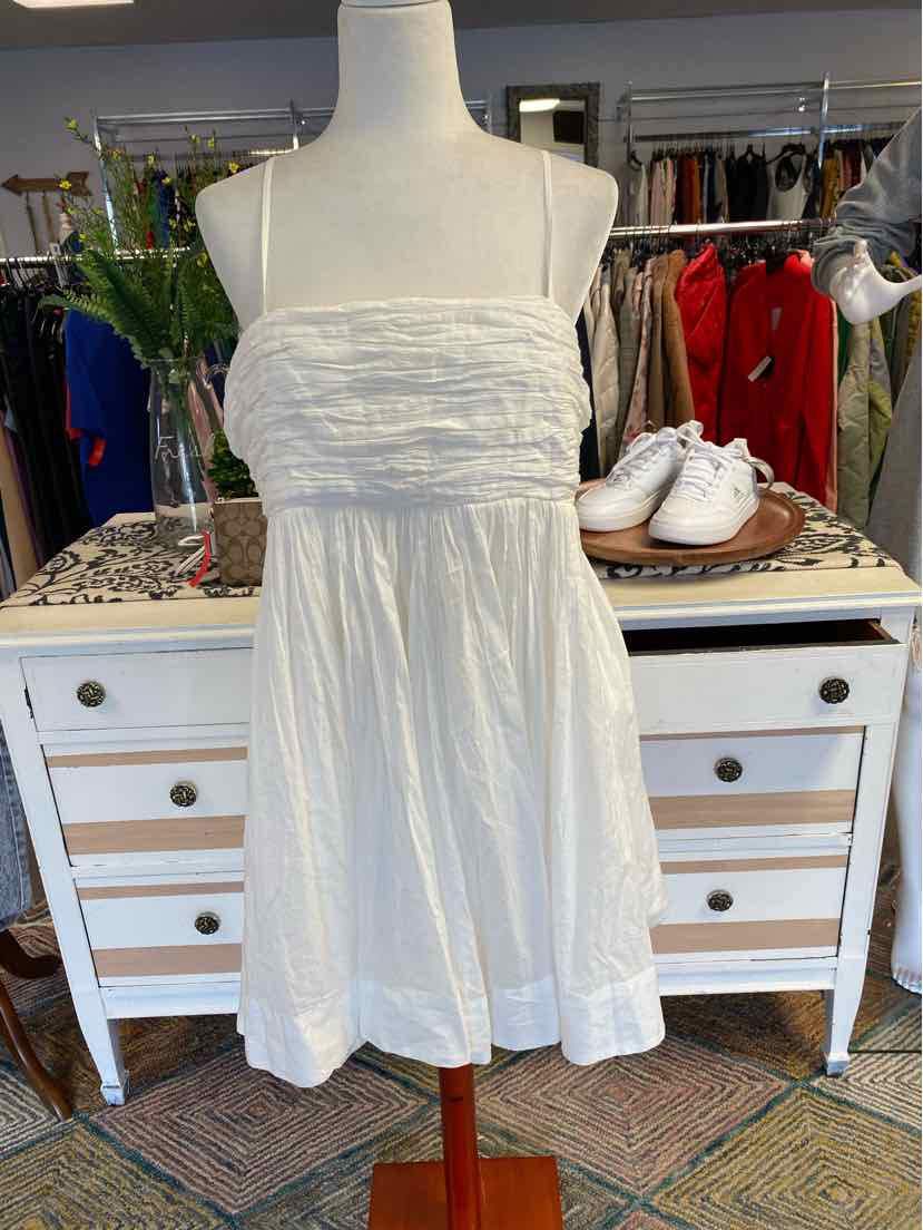 White strapless dress with ruched bodice and flowing skirt on a mannequin.
